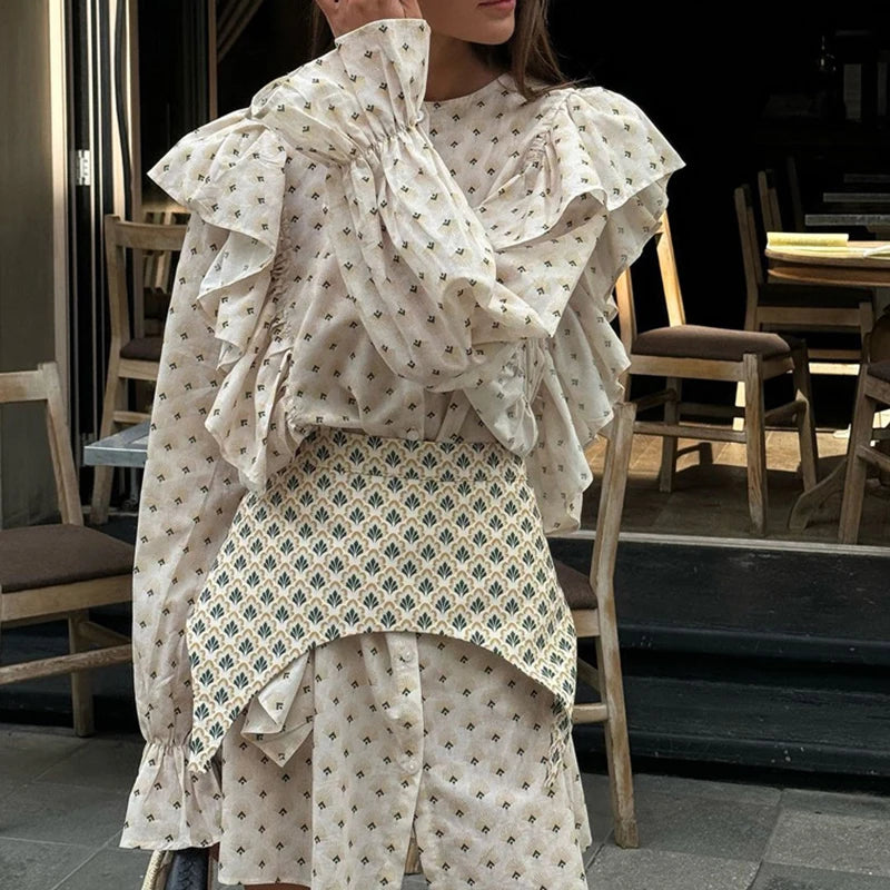 A woman wearing a belted mini dress with a floral print in an indoor setting.