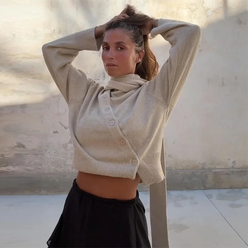 A woman wearing a bevel buckle asymmetric cardigan in a chic, modern style.