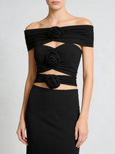 Black off-shoulder slash-neck top with 3D rosette details and cutouts