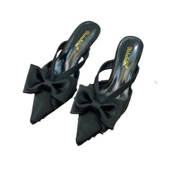 Black bow pointed pumps mules for versatile party and dinner wear on a white background