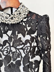 Lower skirt drape of the black maxi dress showing the A-line volume and lace-like texture that catches light in movement.