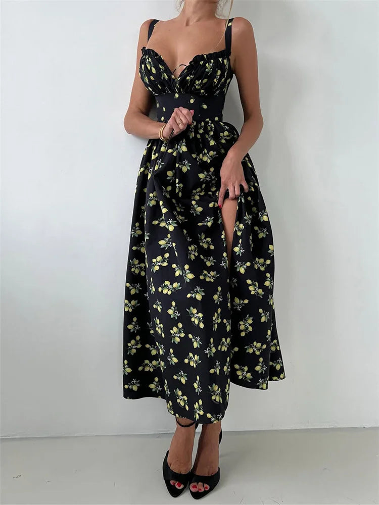 A woman wearing a black floral V-neck maxi dress with a side slit against a white background.