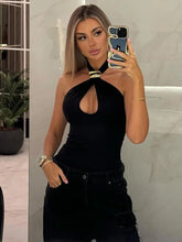 Black halter knit tank top styled with high-waist pants indoors