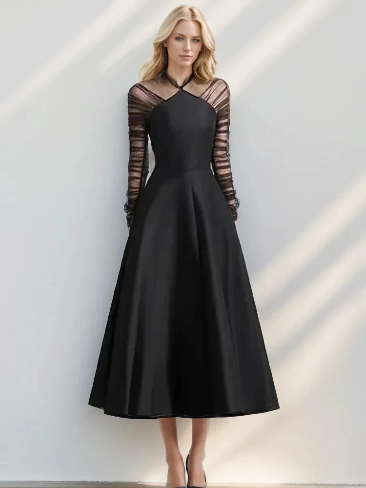 Black halter neck mesh dress styled with long folded sleeves for evening wear