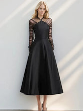 Black halter neck mesh dress styled with long folded sleeves for evening wear