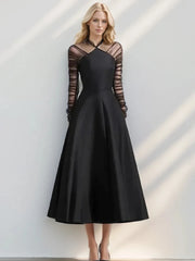 Black halter neck mesh dress styled with long folded sleeves for evening wear