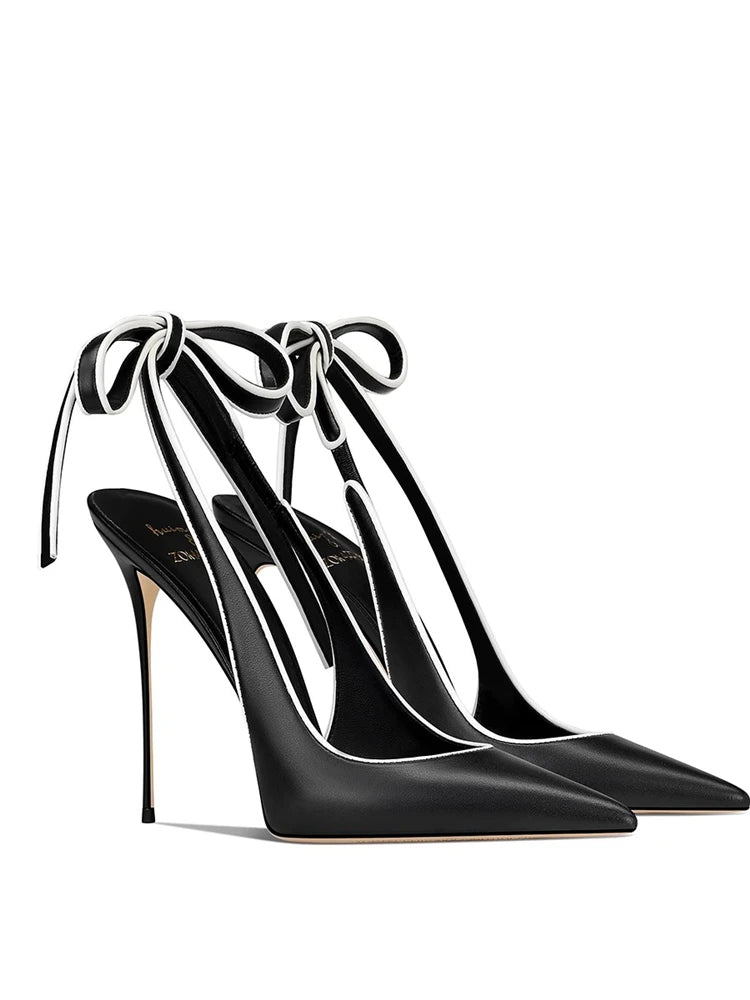 Black high-heeled shoes with ribbon straps on a white background