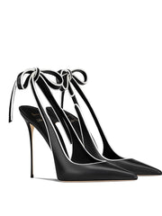 Black high-heeled shoes with ribbon straps on a white background