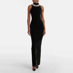 Close-up of beaded patchwork detail framing the open back of a black evening maxi dress.