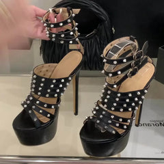 Black high-heeled sandals with studded details on a reflective surface.