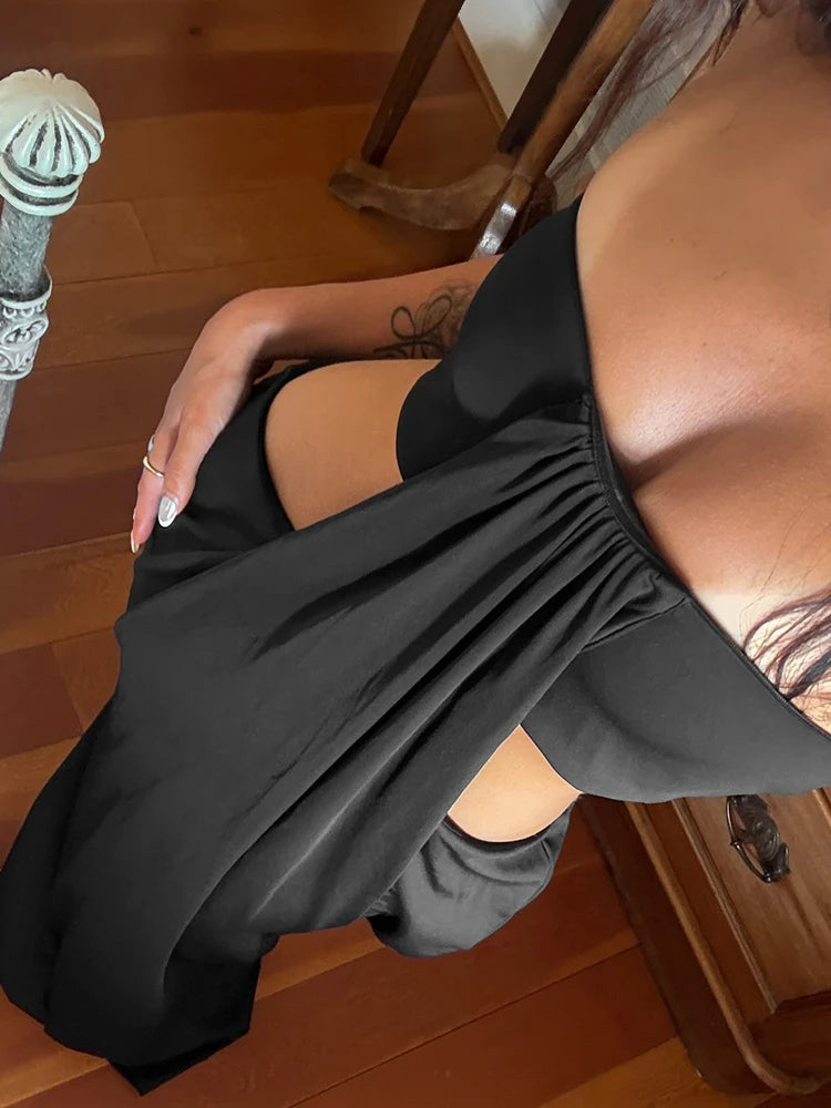 Front view of a black ruched strapless bodycon gown in an indoor setting
