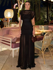 Woman wearing black see-through pleated mesh maxi dress outdoors