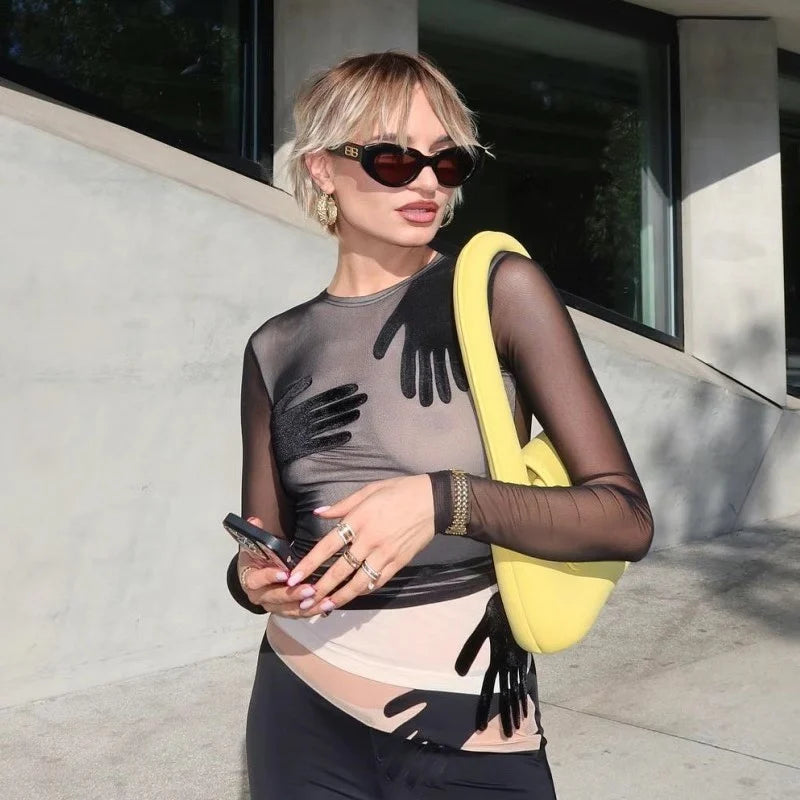 Detail view of the sheer sleeve and hand-motif placement, showing the lightweight mesh texture and smooth, close-to-body fit.