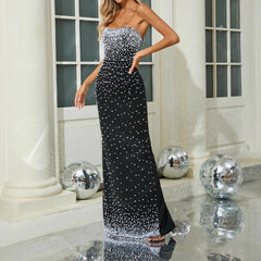 Full-length view of a black strapless maxi dress showing a flowing A-line silhouette and smooth drape.