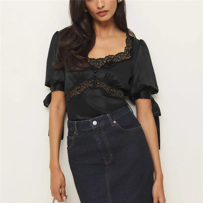 Close-up of black satin blouse featuring delicate lace trim
