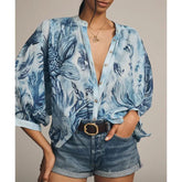 Woman wearing a blue printed lantern sleeve blouse with denim shorts