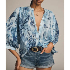 Woman wearing a blue printed lantern sleeve blouse with denim shorts