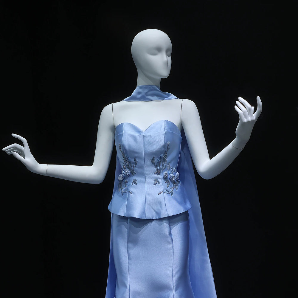 Mannequin wearing a light blue dress with floral embellishments on a black background