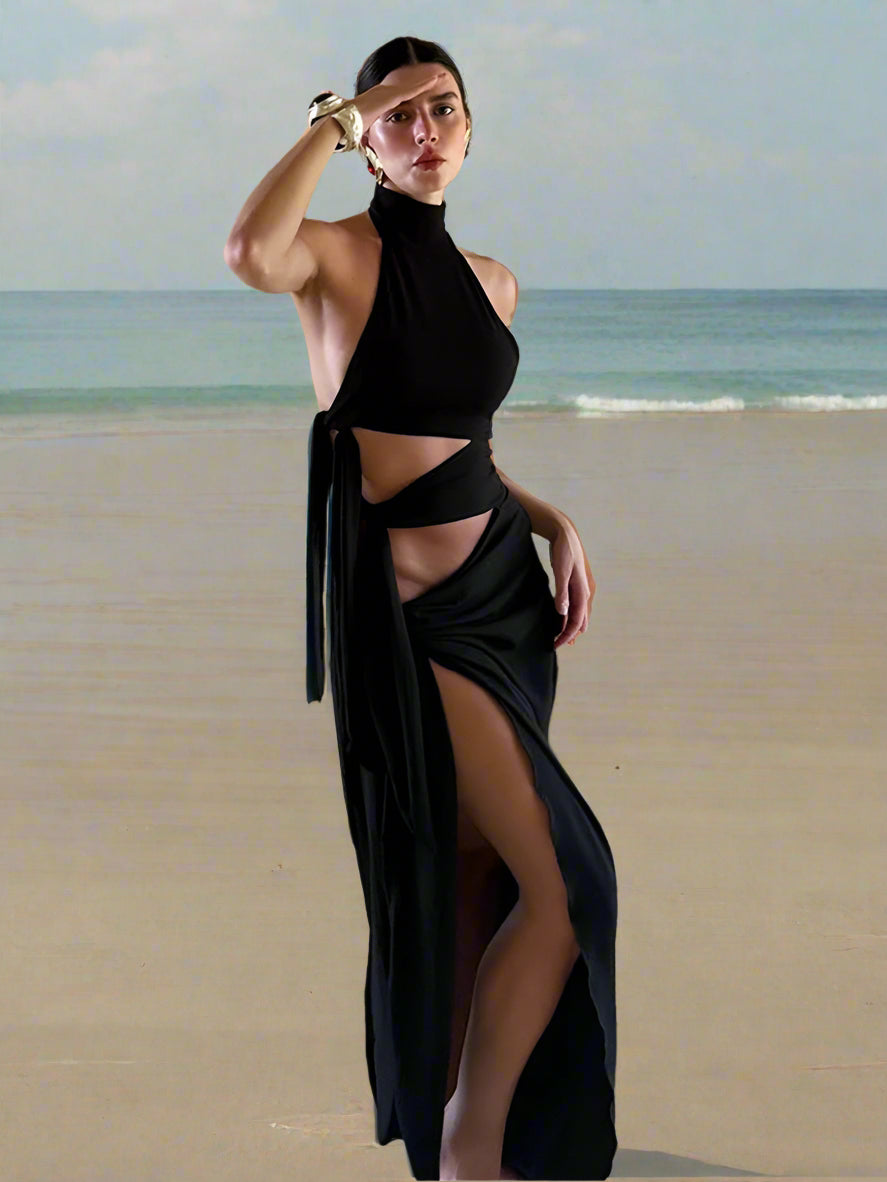 Woman wearing a Bodycon autumn sheath black maxi gown with dramatic high split for partiesn front of a brick wall.