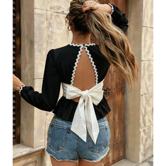 Back view of bow-accent slim blouse with scalloped trim styled casually outdoors
