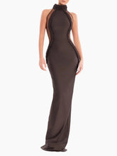 Woman wearing brown halter-neck mesh patchwork sheath maxi evening dress, floor-length, sleeveless, on white background.