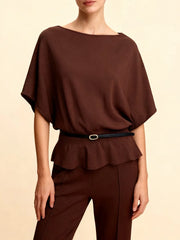 Woman wearing a brown knit belted tunic top on a beige background