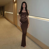 Woman wearing a brown lace patchwork off-shoulder maxi dress in a hallway