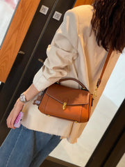 Brown cow leather handbag with zip top and clean stitching along the edges