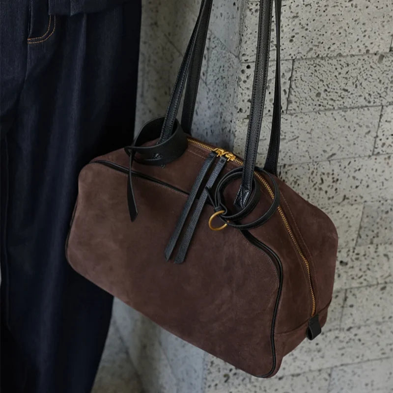 Suede-finish leather handbag shown carried on the shoulder with a structured profile