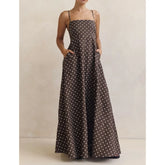 Front view of a brown polka dot maxi dress with square neckline and spaghetti straps, styled simply against a neutral studio backdrop.