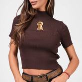 Woman wearing a brown ribbed short sleeve top with a hollow-out detail