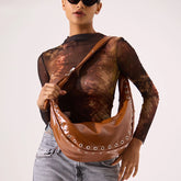 Brown rivet half moon PU hobo bag styled as a crossbody