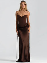 Woman wearing a brown satin strapless maxi dress on a white background