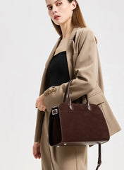 Styled shot of a brown suede leather bag paired with a tailored blazer, giving a polished work-to-weekend look.