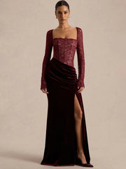 Model wearing a burgundy maxi dress with a lace bodice, square neckline, and long sleeves, posed in a studio on a neutral background.