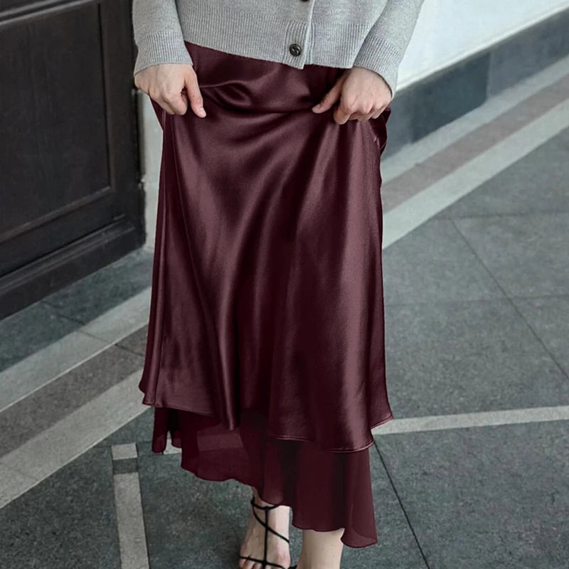 Person wearing a burgundy ankle-length skirt styled with a neutral cardigan on a Varenda.