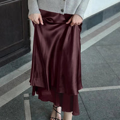 Person wearing a burgundy ankle-length skirt styled with a neutral cardigan on a Varenda.