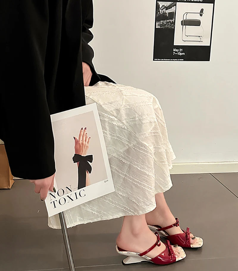 Close-up of butterfly knot detail on red women’s sandals