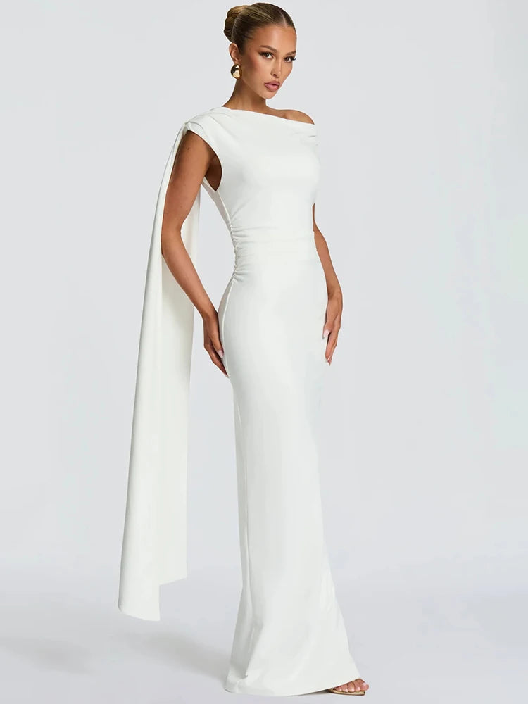 Side angle emphasizing the cape-like drape and fluid motion created while the model walks forward.