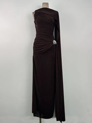 Three-quarter angle emphasizing the one-side cape detail and clean high neckline, styled minimally for a black-tie-leaning evening look.