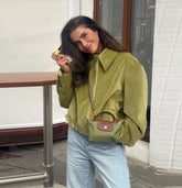 Casual green jacket paired with light blue jeans for modern street style