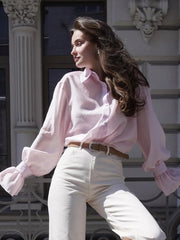 Button-up pink shirt styled casually with feminine flair