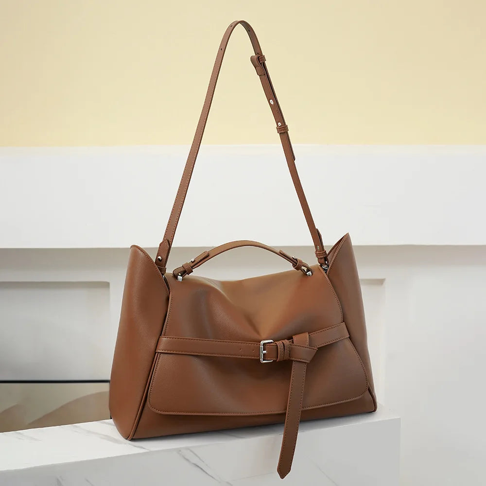 Casual brown underarm bag shown held by a woman in a beige coat