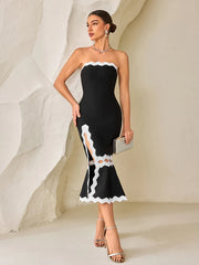 Woman wearing a celebrity cocktail sculpted midi dress in black and white for summer events against a neutral background