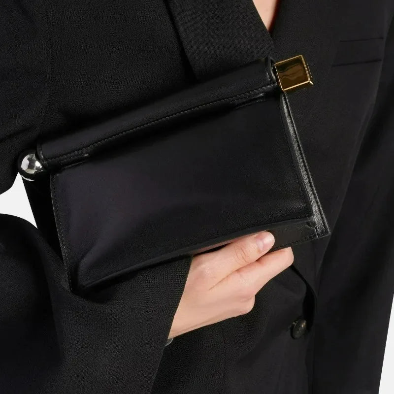 Close-up of rolled top edge and metal hardware on foldover clutch