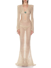 Full-length champagne openwork knit maxi dress with long sleeves and deep V neckline, finished with a central jewel detail.