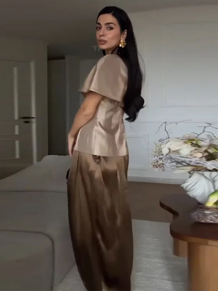 Close view of the neckline and fabric finish on a cape-sleeve top