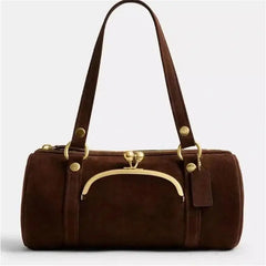 Close-up of clip-buckle hardware and curved front detail on handbag