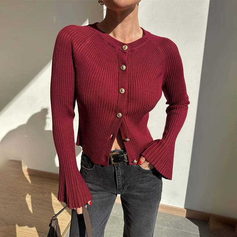 Close-up of ribbed texture and gold button detailing on cardigan