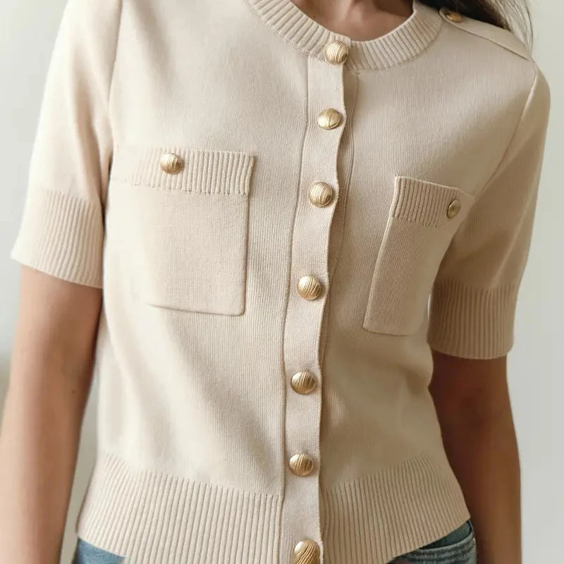 Close-up of gold buttons and ribbed knit texture on a neutral background